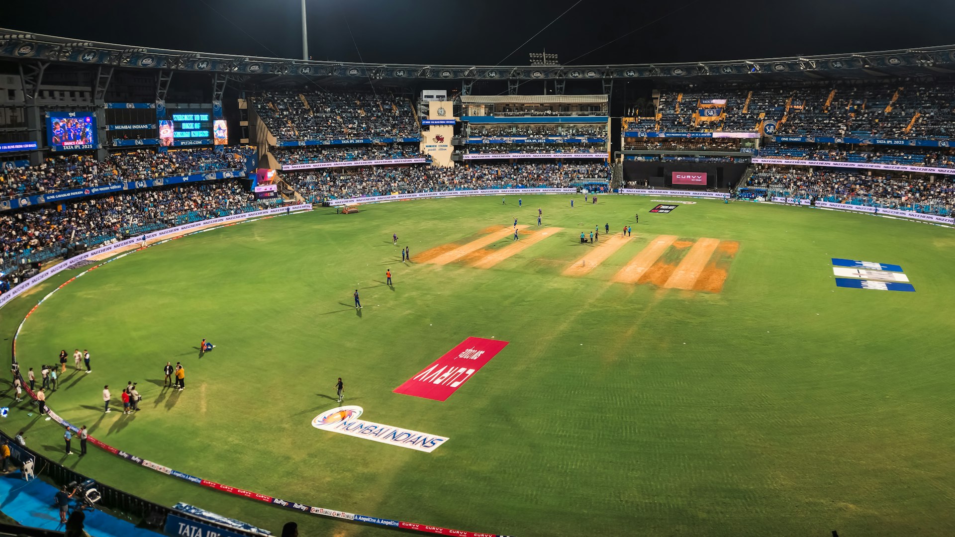 A cricket match is underway at a stadium.